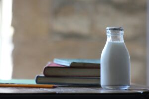 Milk in front of a stack of books