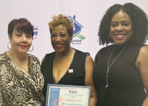 Kathleen Lowe Jacobs and Dr. Ericka J. Whitaker stand with attendee and award